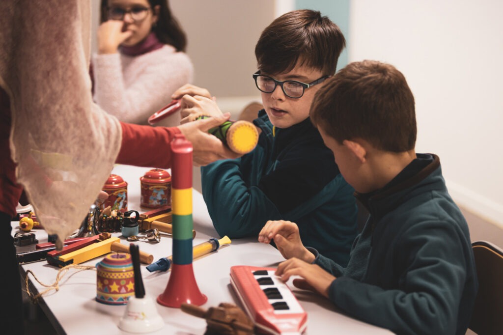 des enfants jouent avec des objets sonores pour composer l'ambiance du feuilleton radio